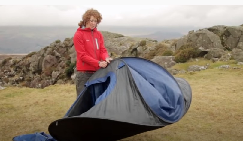 Woman Folds the top two poles together